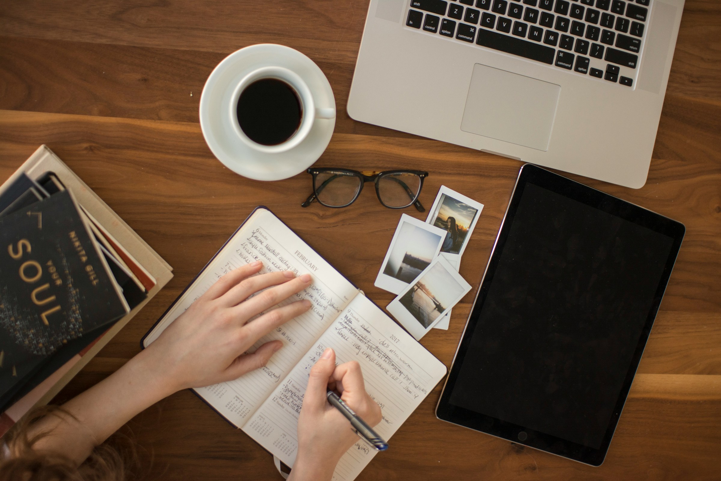 Contact laptop met koffie, bril, notitieboekje en tablet