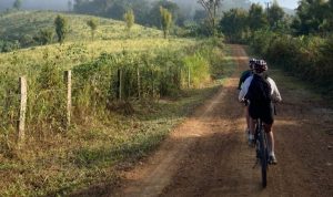 Laos, mensen op fiets door de velden
